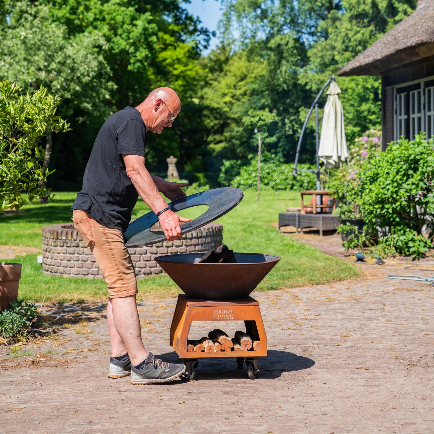 BBQ Plancha Grill Brasero Feuerschale Cortenstahl mit großen Rädern, Holzlager und Backblech Ø80cm