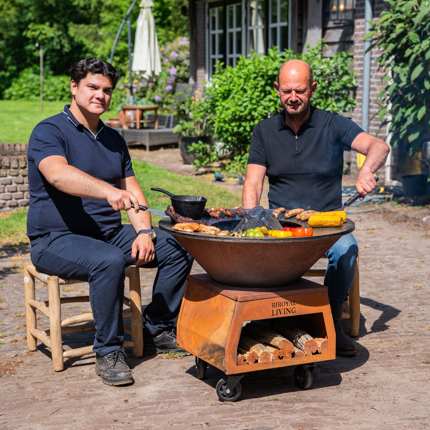 BBQ Plancha Grill Brasero Feuerschale Cortenstahl mit großen Rädern, Holzlager und Backblech Ø80cm