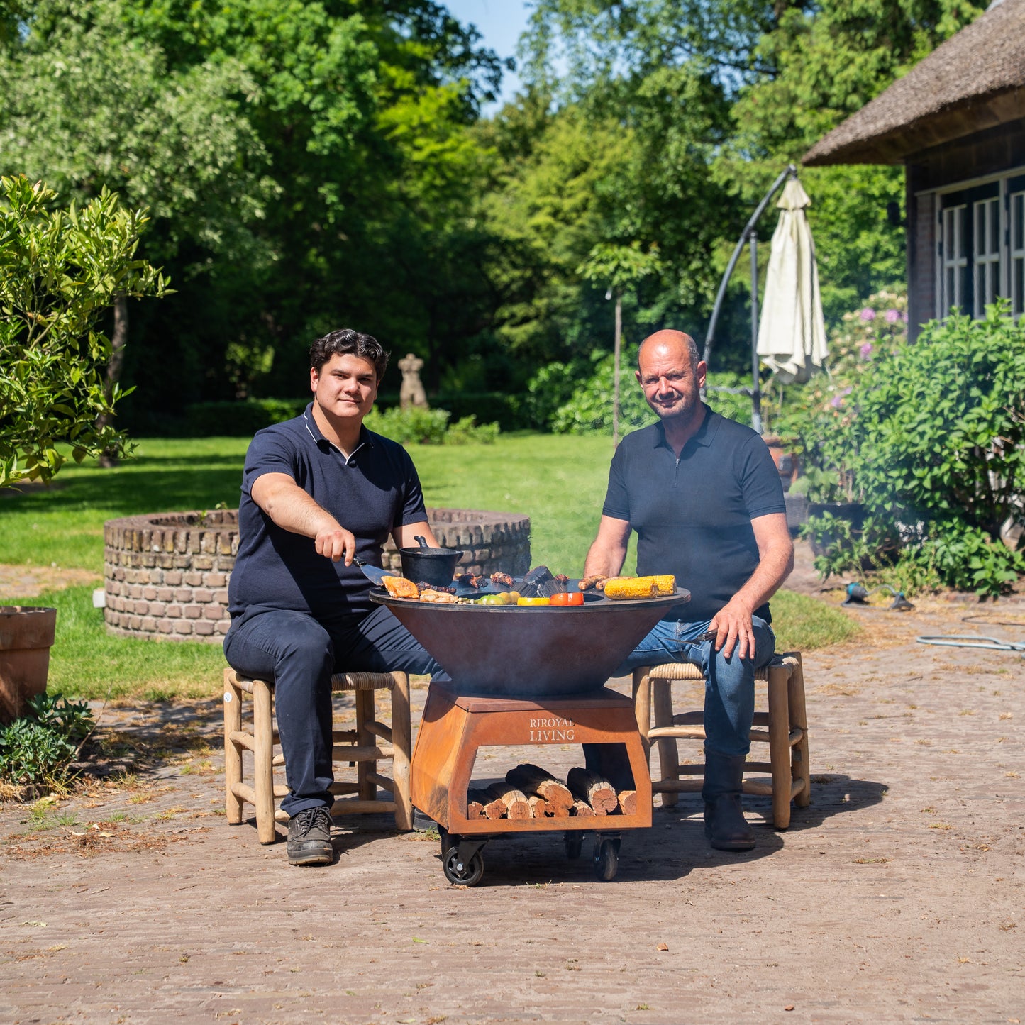 BBQ Plancha Grill Brasero Feuerschale Cortenstahl mit großen Rädern, Holzlager und Backblech Ø80cm