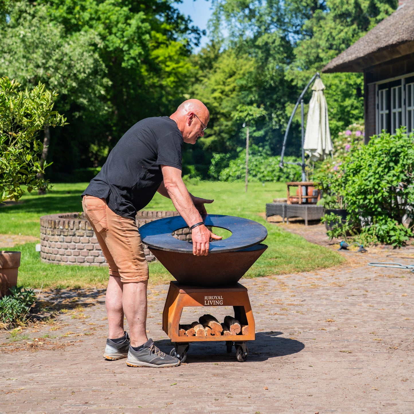 BBQ Plancha Grill Brasero Feuerschale Cortenstahl mit großen Rädern, Holzlager und Backblech Ø80cm