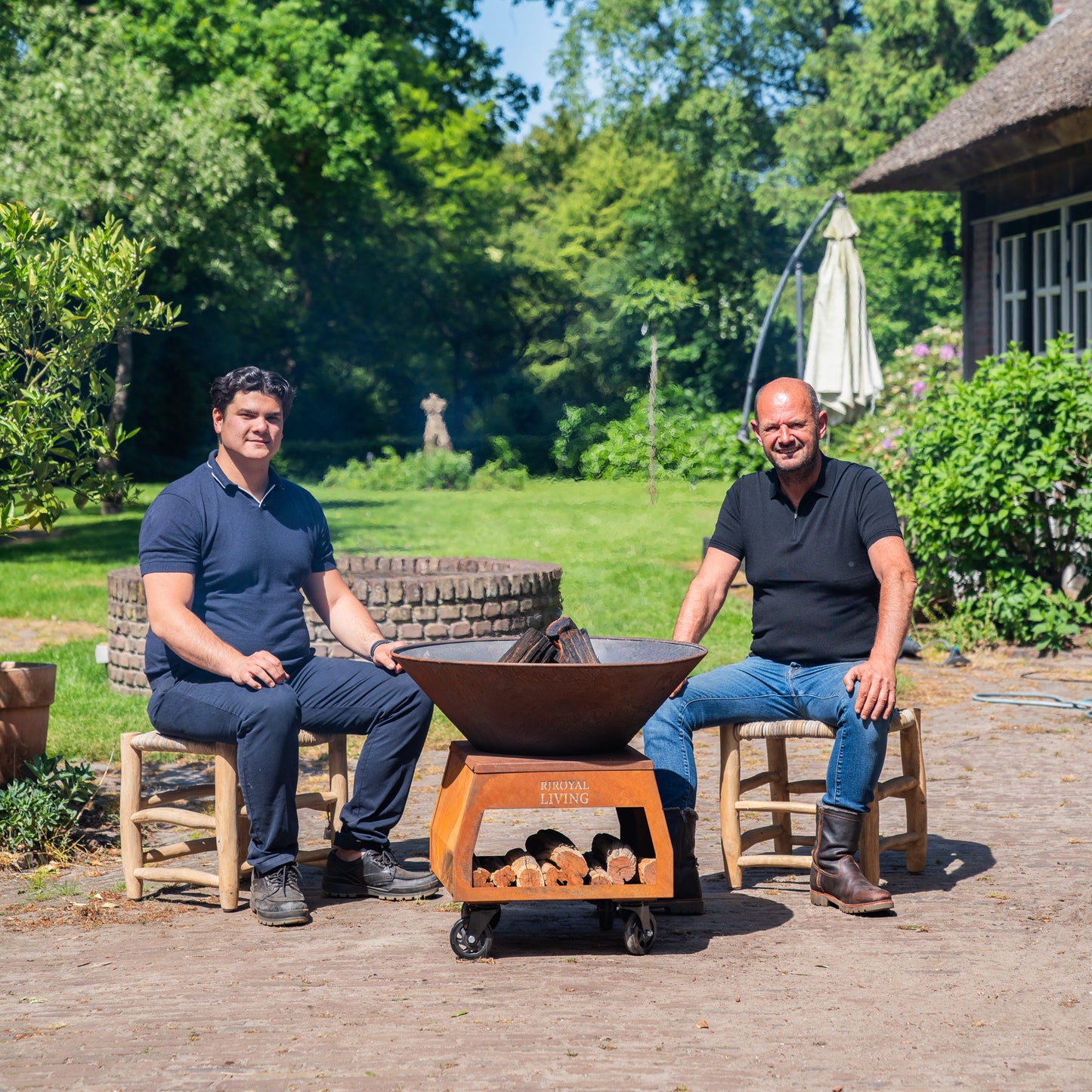 BBQ Plancha Grill Brasero Feuerschale Cortenstahl mit großen Rädern und Holzlagerung Ø75cm