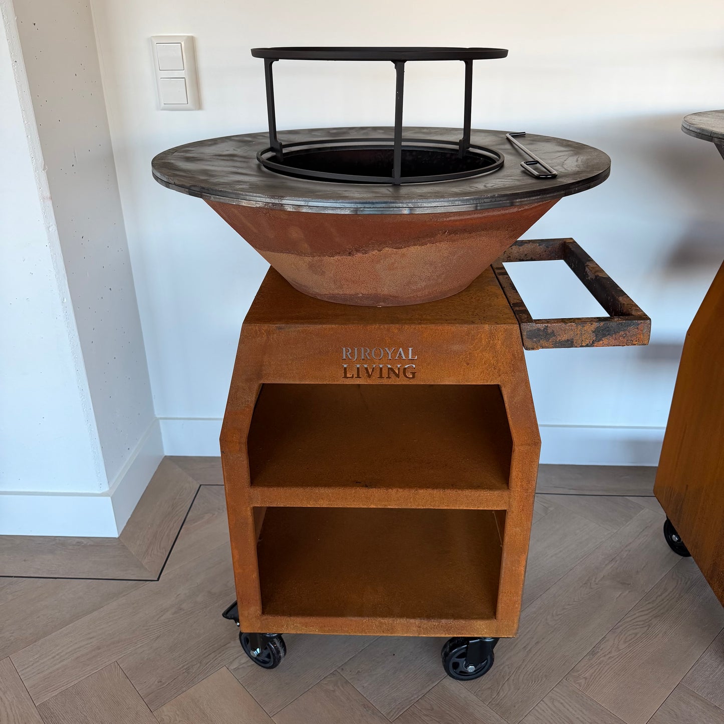 BBQ Plancha Grill Maestro Ø70cm Cortenstahl – Mit großen Rädern und Holzlager