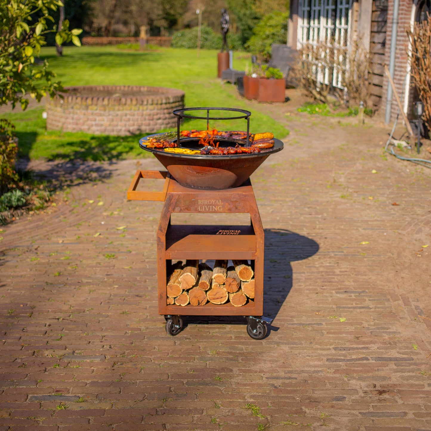 BBQ Plancha Grill Maestro Ø70cm Cortenstahl – Mit großen Rädern und Holzlager